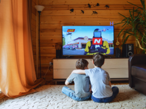 Two children hug while watching television